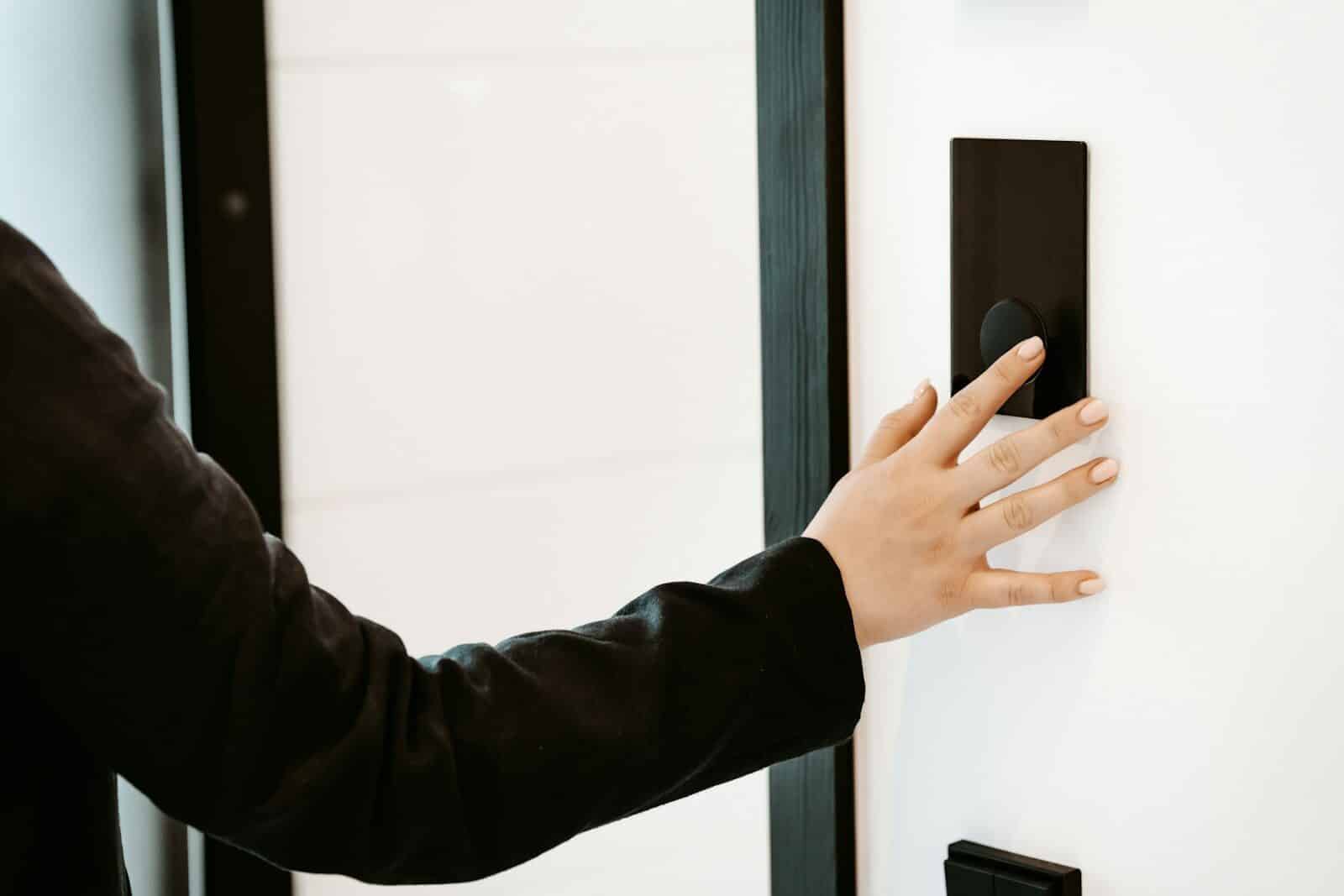 a person is pressing a button on a white wall